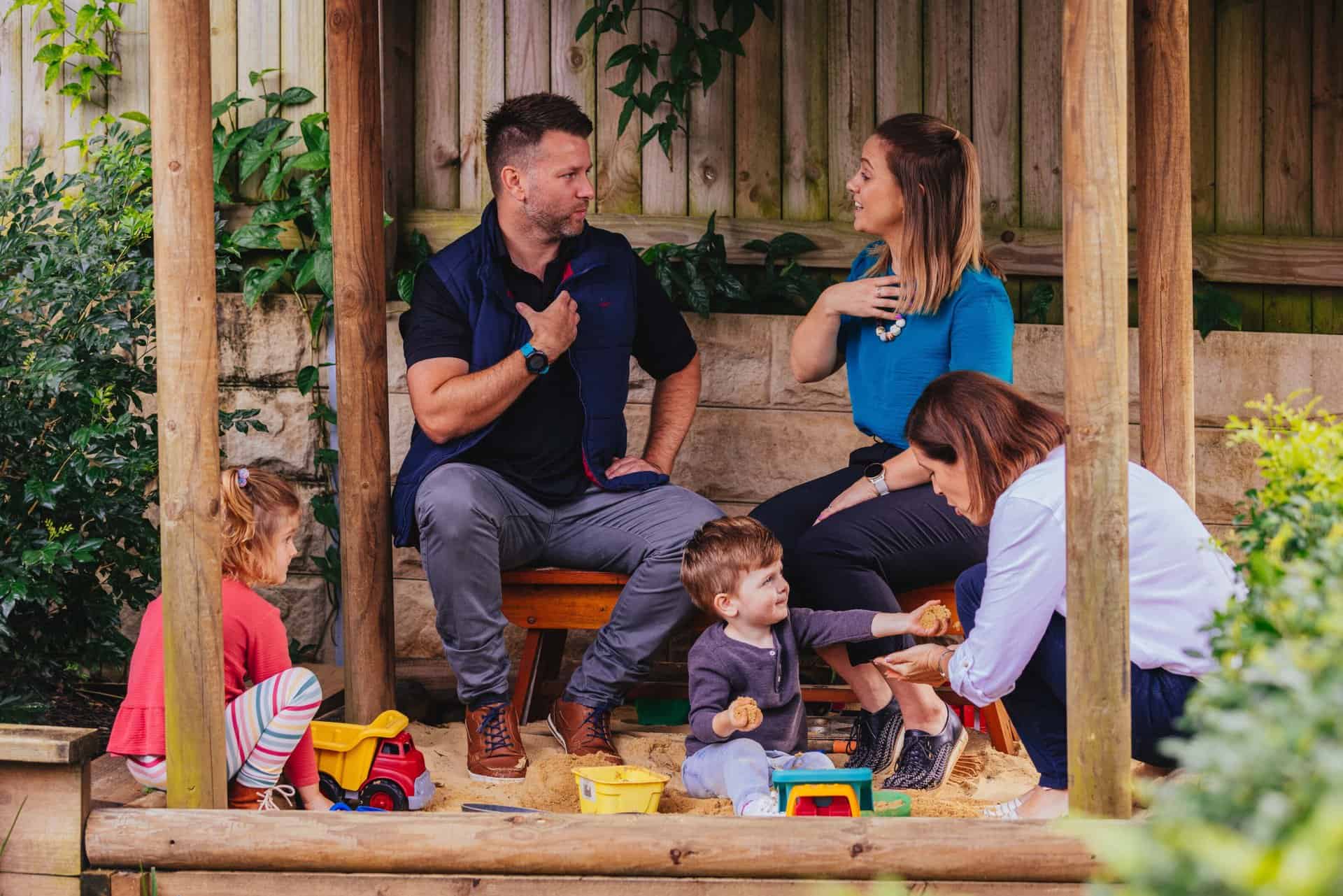 therapy for kids therapists working together with parents and children in a sandpit